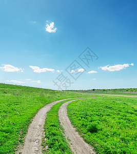 绿地上的肮脏道路阳光土地蓝色小路国家晴天场地环境风景天空图片