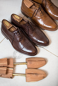 布朗男子的鞋子和鞋裤男人木头古董蕾丝衣架软垫棕色庄家鞋带担架背景图片