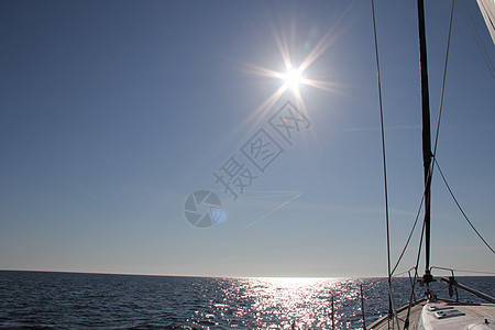 航行在地平线上太阳天空蓝色海洋图片