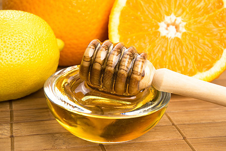 含柠檬和橙子水果的新鲜蜂蜜甜食餐具早餐金子玻璃木头健康饮食美食家食物勺子图片