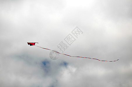 一个Kite飞过云天闲暇游戏家庭乐趣飞行天空空气红色蓝色细绳图片