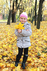 公园里有黄色叶子的小女孩衣服生活闲暇孩子童年游戏孩子们幸福姿势地面图片