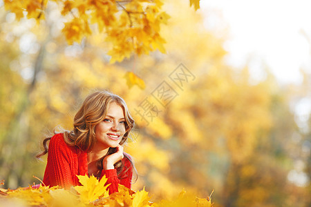 女人躺在秋叶上叶子幸福女孩橙子森林微笑金子快乐公园女性图片