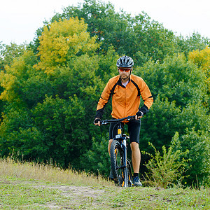 赛车员在美丽的秋季森林中骑自行车蓝色骑士竞赛下坡速度天空男性乐趣车轮男生图片