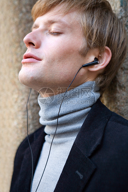 用耳机收听音乐乐趣力量青年街道城市数字学生幸福友谊男性图片