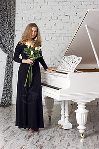 弹钢琴的年轻美少女金发钥匙裙子长处旋律女士奢华音乐会成人魅力图片
