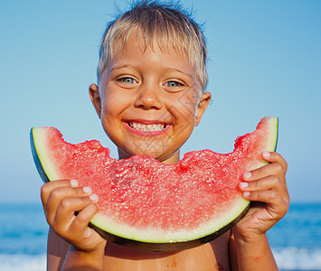 男孩吃西瓜小吃眼睛快乐童年喜悦水果青年孩子们享受营养图片