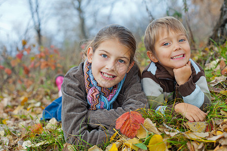 秋天公园的孩子童年孩子们女性蓝色围巾太阳森林男生树叶晴天图片