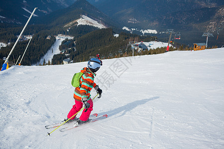 女孩在滑雪板上自由婴儿孩子们女性越野头盔运动粉末季节娱乐图片