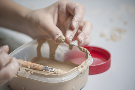 女孩用泥土做玩具文化陶瓷车轮创造力艺术设计师手指洞察力纺纱雕塑家图片