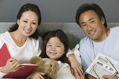 一个亚洲家庭的肖像 在家里一起在床上放松的图片