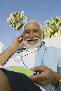 坐在户外的老人听耳机低角度画像 (笑声)图片