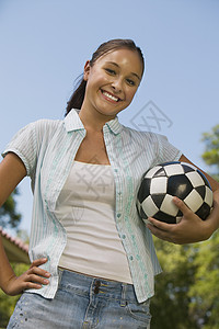 年轻女子握着足球舞会图片