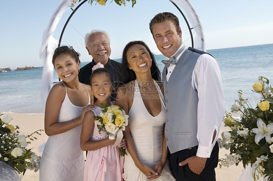 与家人在海滩上的新娘和Groom肖像幸福亲戚们燕尾服男子伙计们新郎誓言衣服爸爸们人像图片