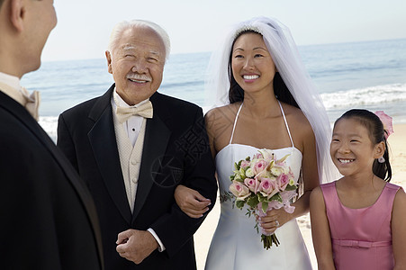 与家人在海洋的新娘和Groom图片