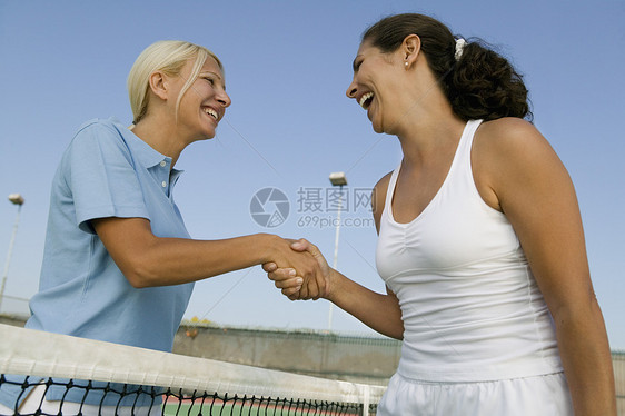两个女性网球玩家在网球法庭上 握着网球场净低角度视图图片