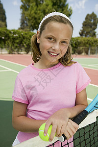 在网球场肖像上 玩网球和打网球的年轻女孩图片