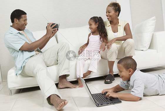 坐在沙发上的家庭坐落在沙发上图片