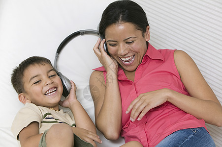 母亲和儿子躺在沙发上分享耳机图片