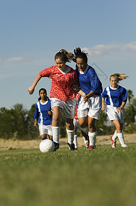 年幼女孩在田地上踢足球对抗天空游戏青年服饰娱乐运动比赛消遣竞争队友全身图片