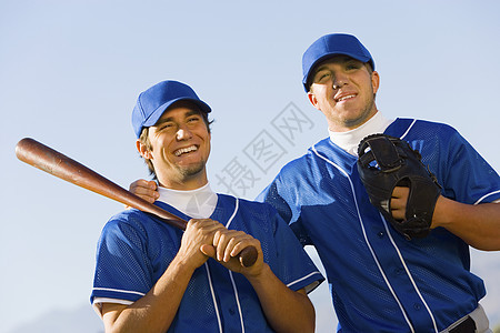 快乐的年轻棒球运动员的肖像 站在清空的天空上图片
