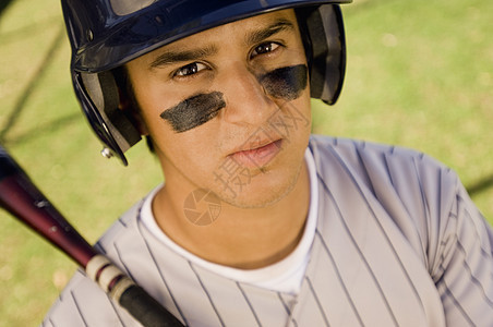 一名年轻的高加索棒球运动员拿着球棒的肖像图片