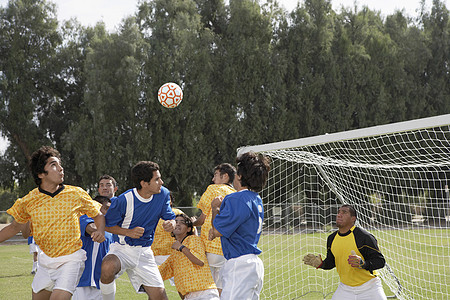 足球运动员为球而跳男子棕榈团队制服球类服装专注跳跃成年挑战图片