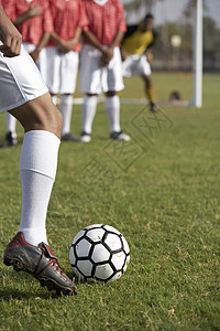 低层足球运动员在背景中与反对者一起玩Freekick图片