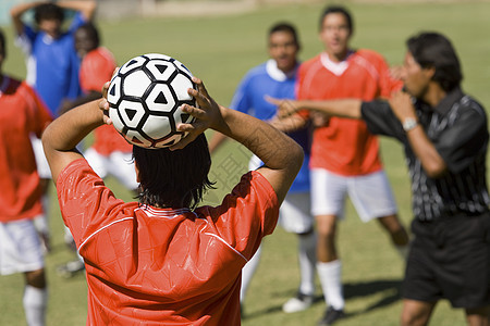 足球玩家向球后投球图片