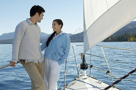 快乐的情侣在坐帆船时互相看着对方图片