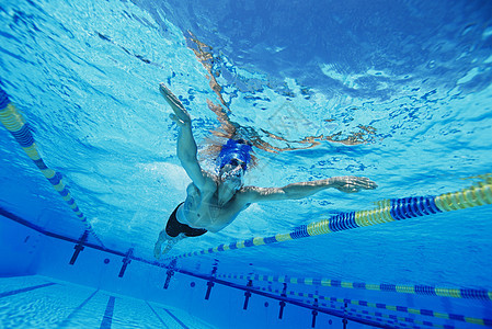 一个在水下游泳的年轻人的低角度视角中年男性中年人泳帽游泳池男子摄影倾斜头饰精力图片
