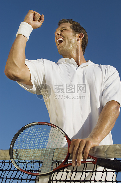 成年男性网球运动员庆祝成功时的低角度观景图片