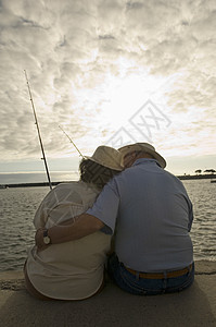 在海滩钓鱼的浪漫老年情侣近视图片
