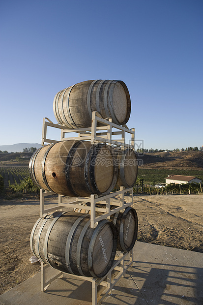 木制红酒桶堆在背景中与房屋站在一起的摊位上图片
