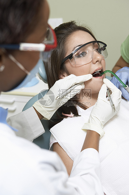 牙医在牙科诊所检查病人牙齿的特写镜头图片