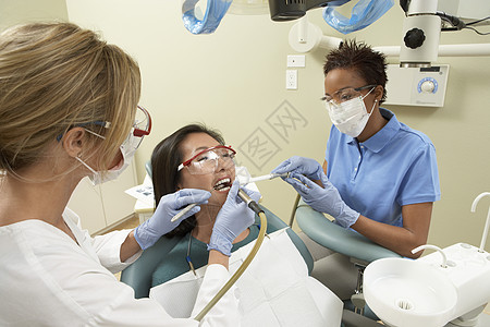 护士协助牙医在治疗期间用口水喂病人的嘴图片