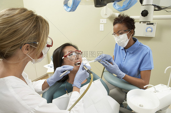 护士协助牙医在治疗期间用口水喂病人的嘴图片