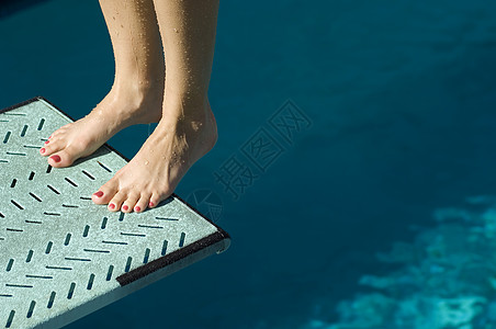 从弹簧板边缘潜水的女性游泳员的低区域视图(从春季板边上潜出)图片