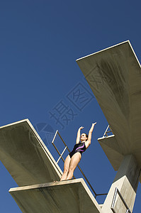 一个女游泳员的低角度视角 准备从弹簧板下潜图片