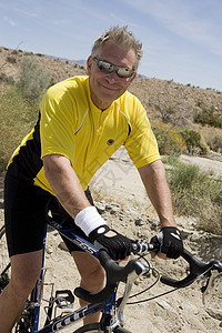 一个快乐的老人骑自行车的肖像头发男子生活方式倾斜活动沙漠运动闲暇中年半身图片