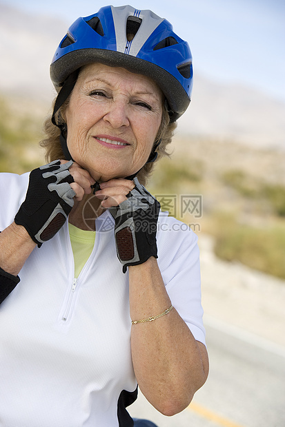 一位身戴头盔的快乐高龄妇女的肖像图片