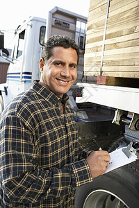 一个微笑着的男上司的肖像 用装满木材的卡车剪贴板图片