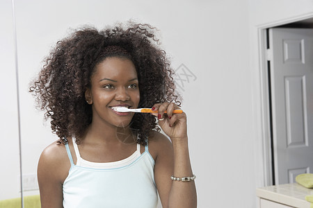 非洲裔美国年轻妇女在浴室刷牙的女青年图片