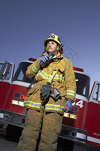 一位成熟的消防员谈论对讲机的低角度视角图片