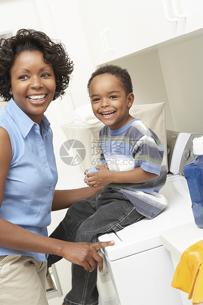 美籍非裔母亲和儿子在洗衣房的衣橱里图片