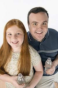 快乐的父亲和女儿拿着水瓶的肖像图片