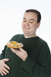 中年男子看甜甜圈 孤立于白种背景图片