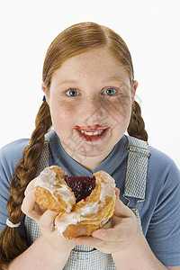 少女吃甜甜圈的肖像与白种背景隔绝图片