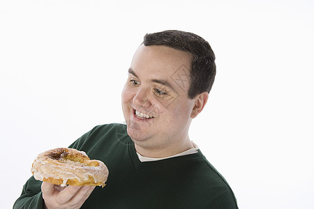 带着美味甜甜甜圈的中年男子在白种背景上被孤立图片