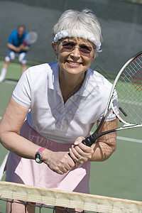 在法庭上打网球的快乐高龄妇女图片